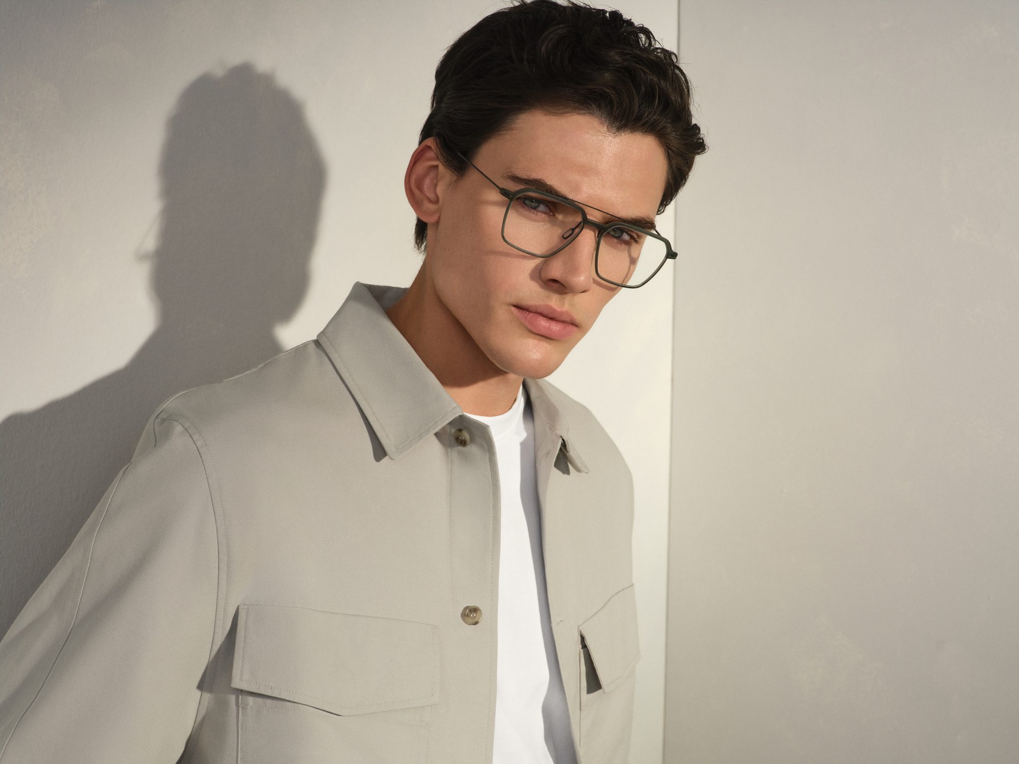 Man in a light jacket wearing Rodenstock eyeglasses in warm side light