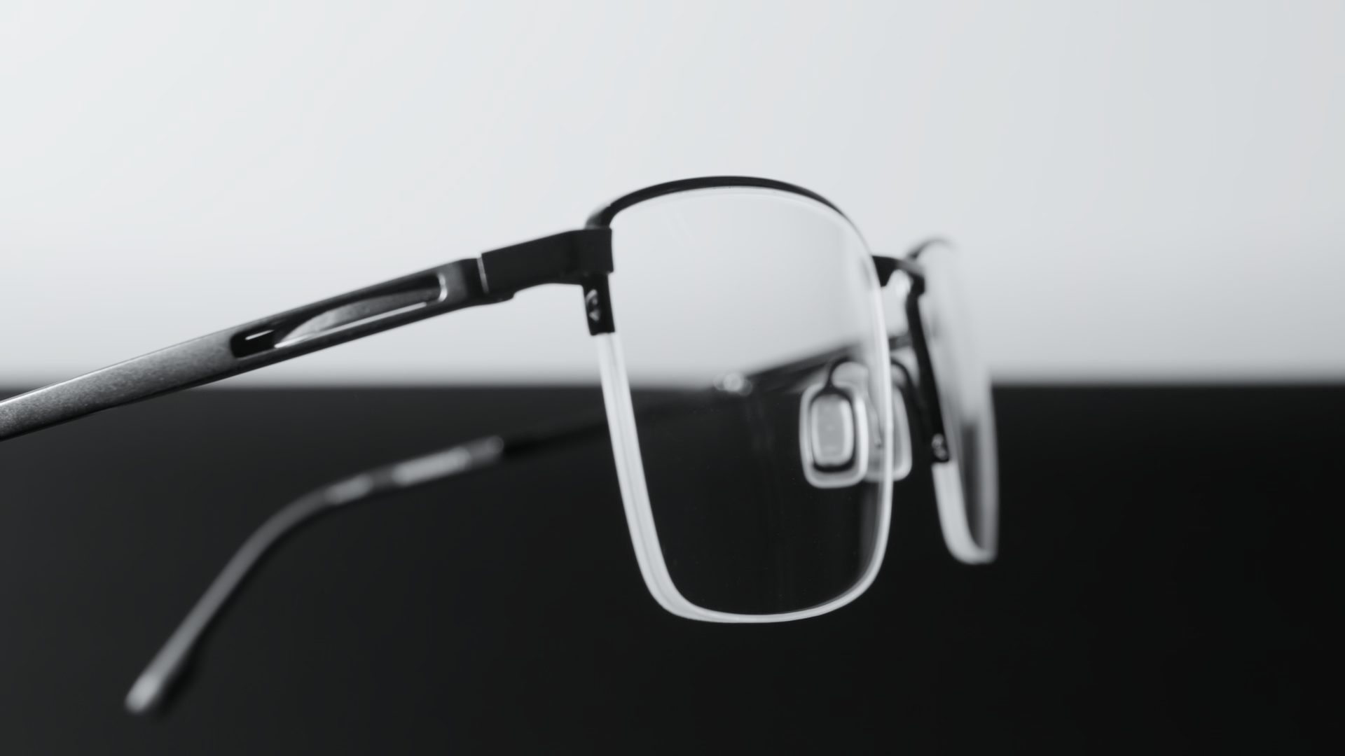 InfiniTec key visual: macro view of a half-rim titanium frame and nose pad